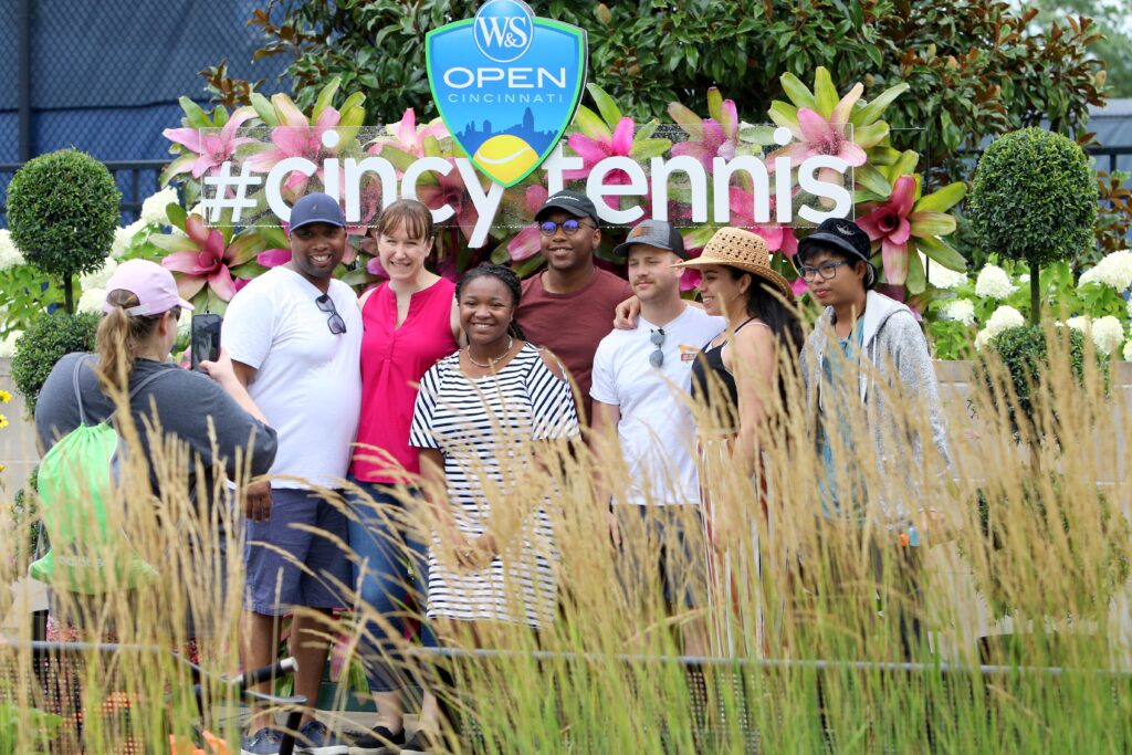 A group of fans taking a picture in front of cincytennis back drop