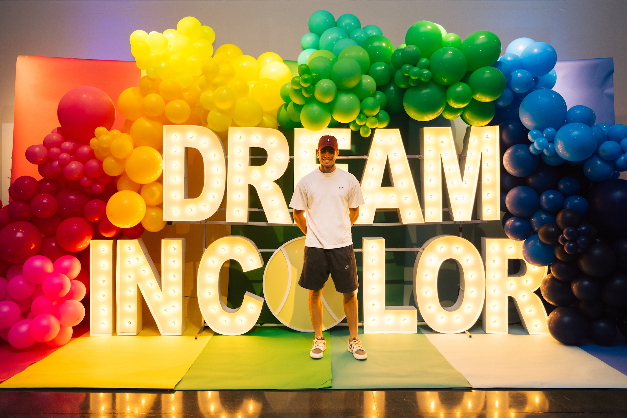 Player standing in front of a marquee letters spelling "Dream in Color".
