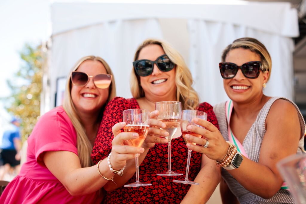 Three women lift their champagne glasses together