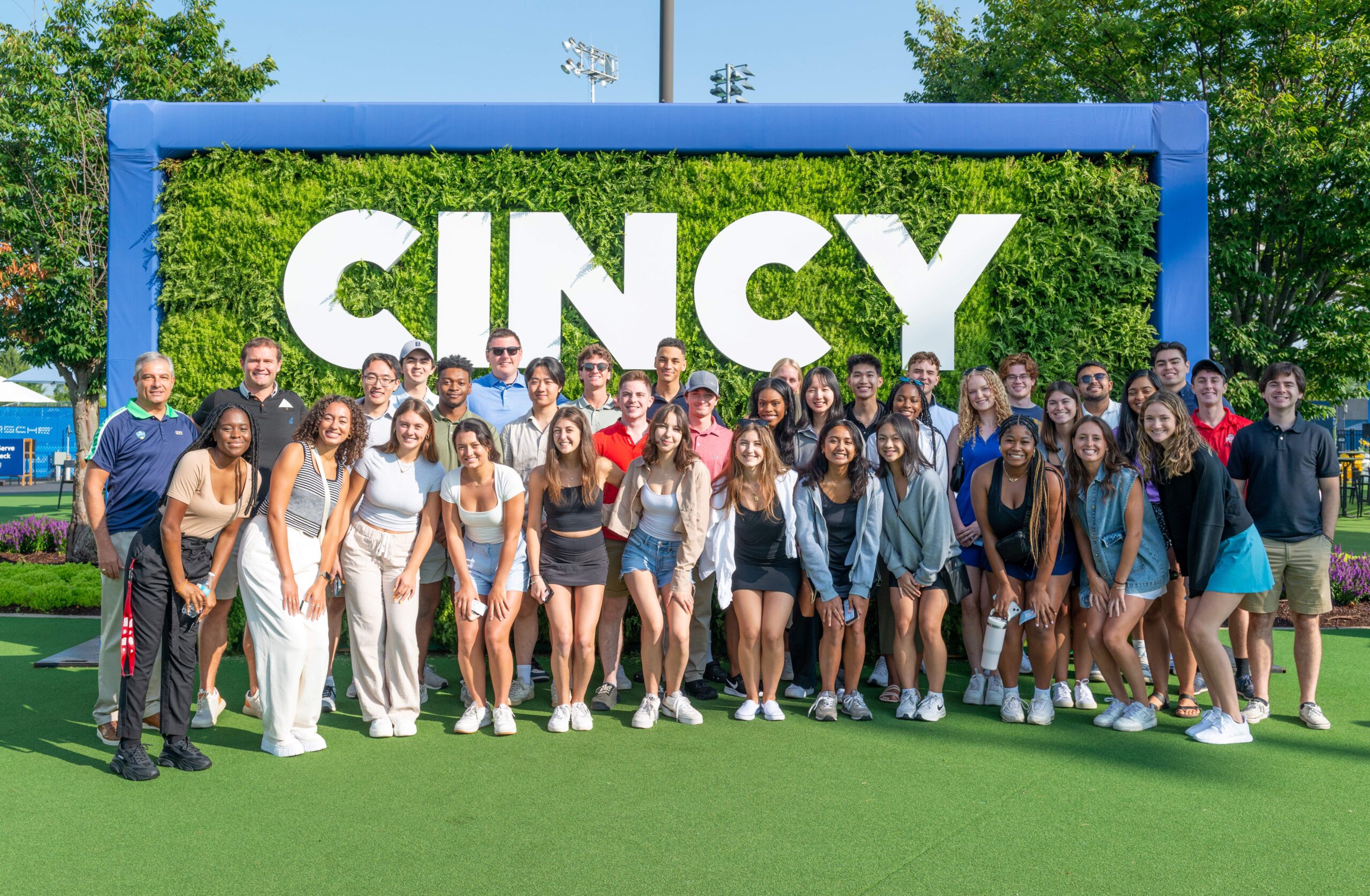 A group of people standing in front of a "Cincy" sign