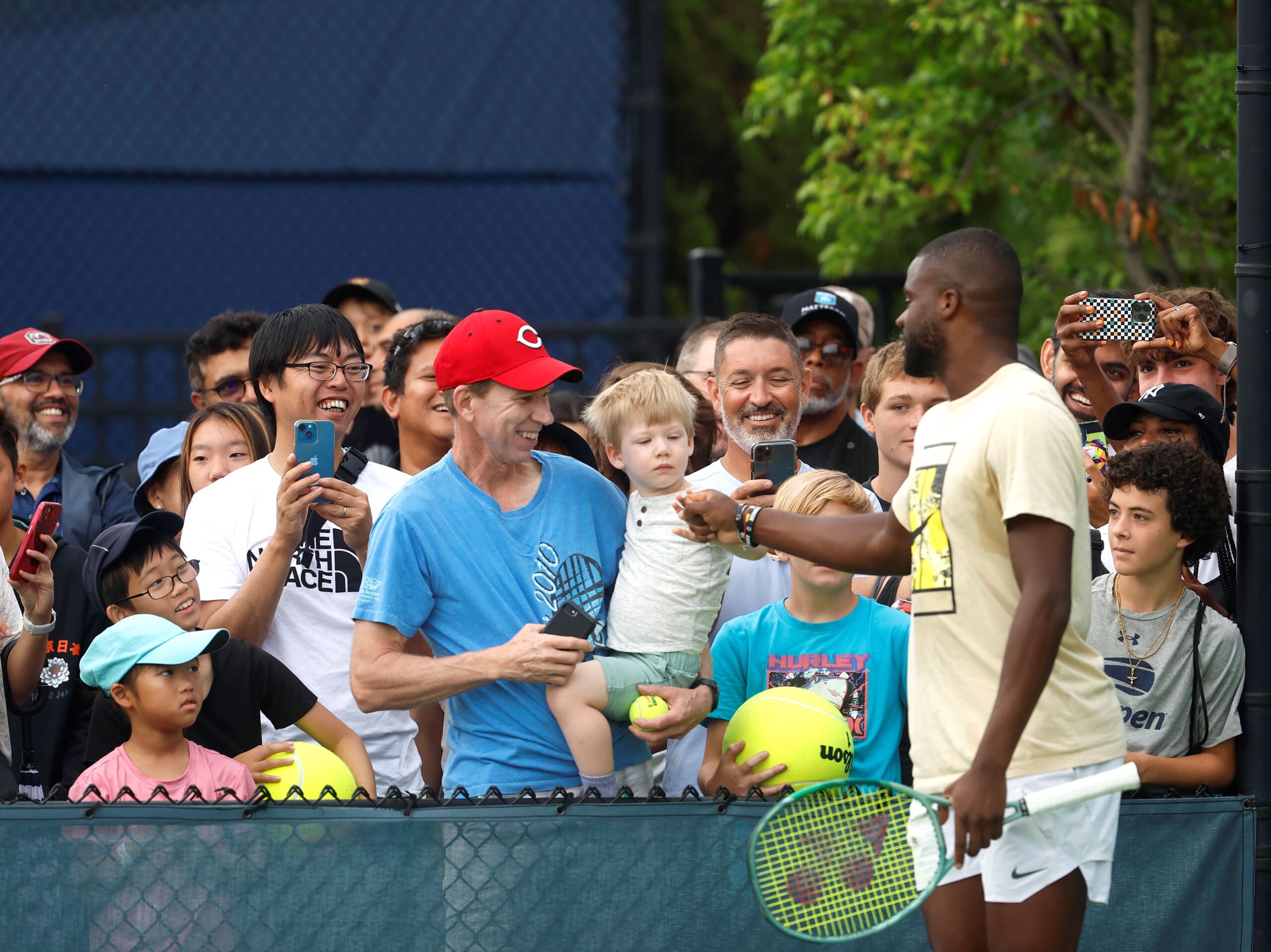 Frances Tiafoe fist bumps a young fan