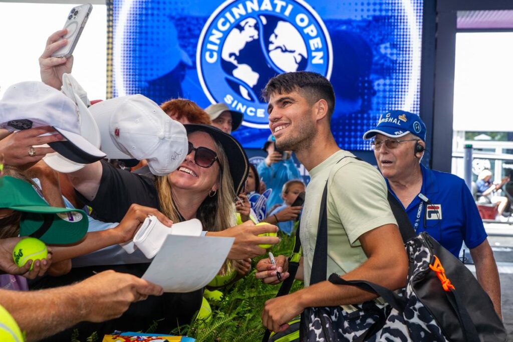 Carlos Alcaraz smiling with fans.