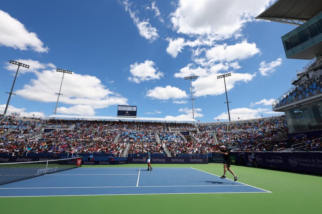 Tennis court with people in bleachers.