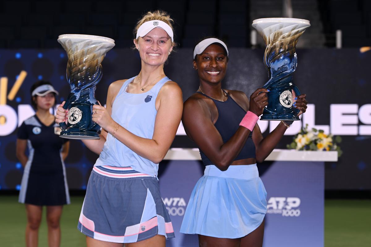 women's doubles champions pose with trophy