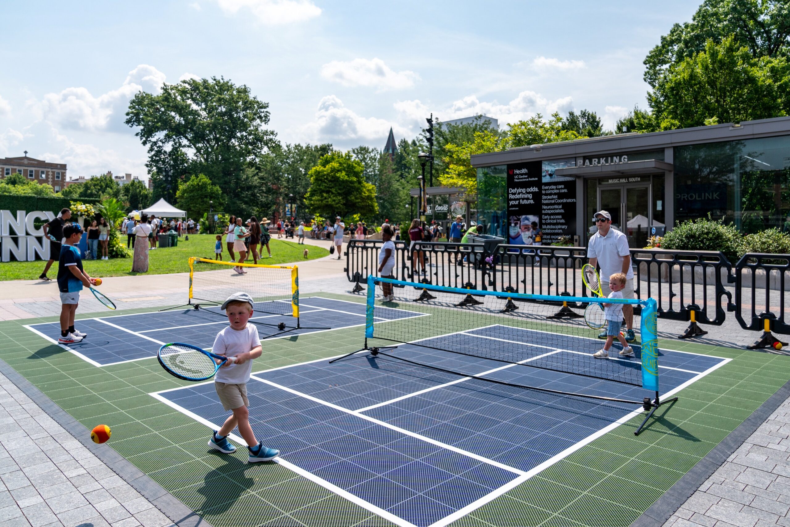 Young fans play on a miniature tennis court at Fan Fest.