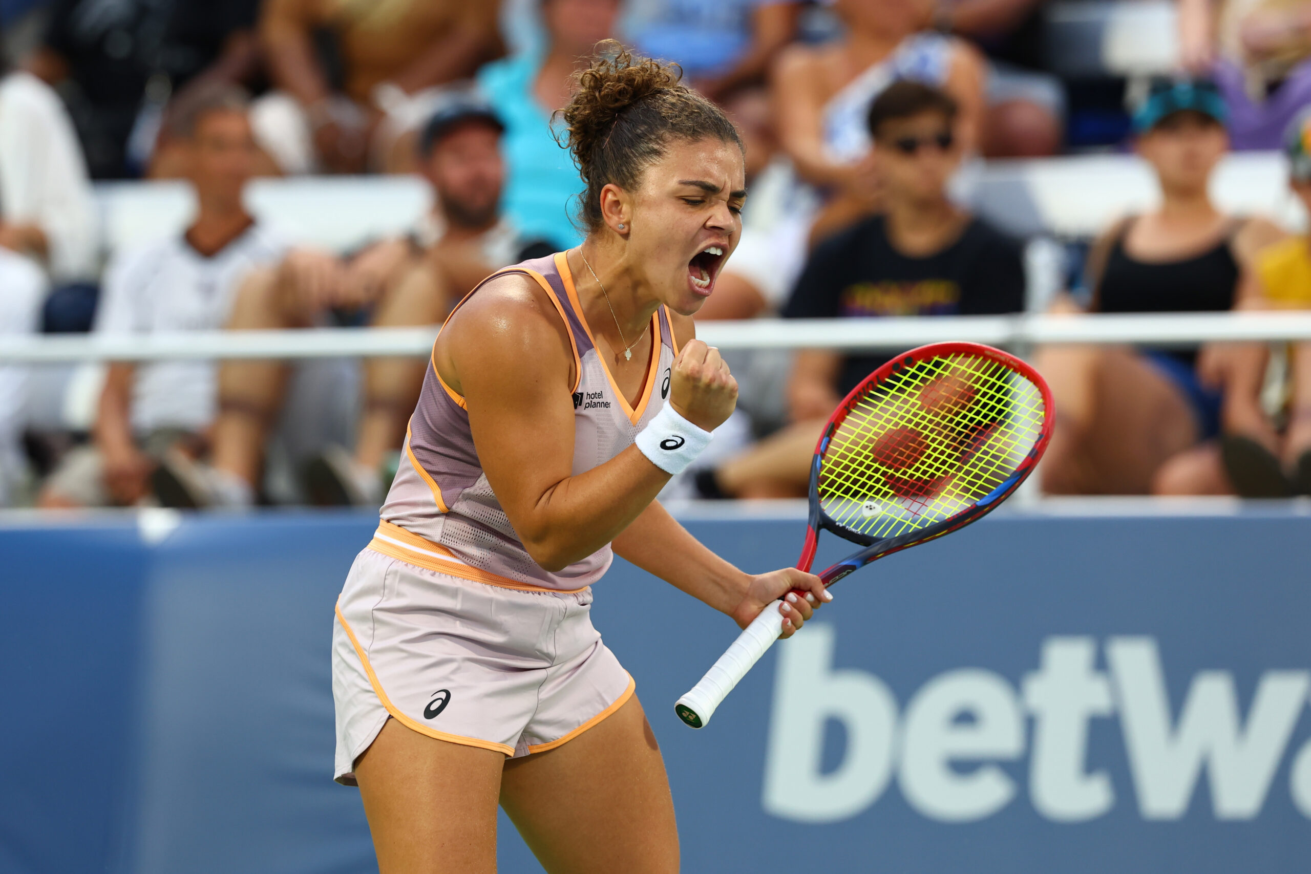 A player fist pumps and celebrates with crowds behind them.