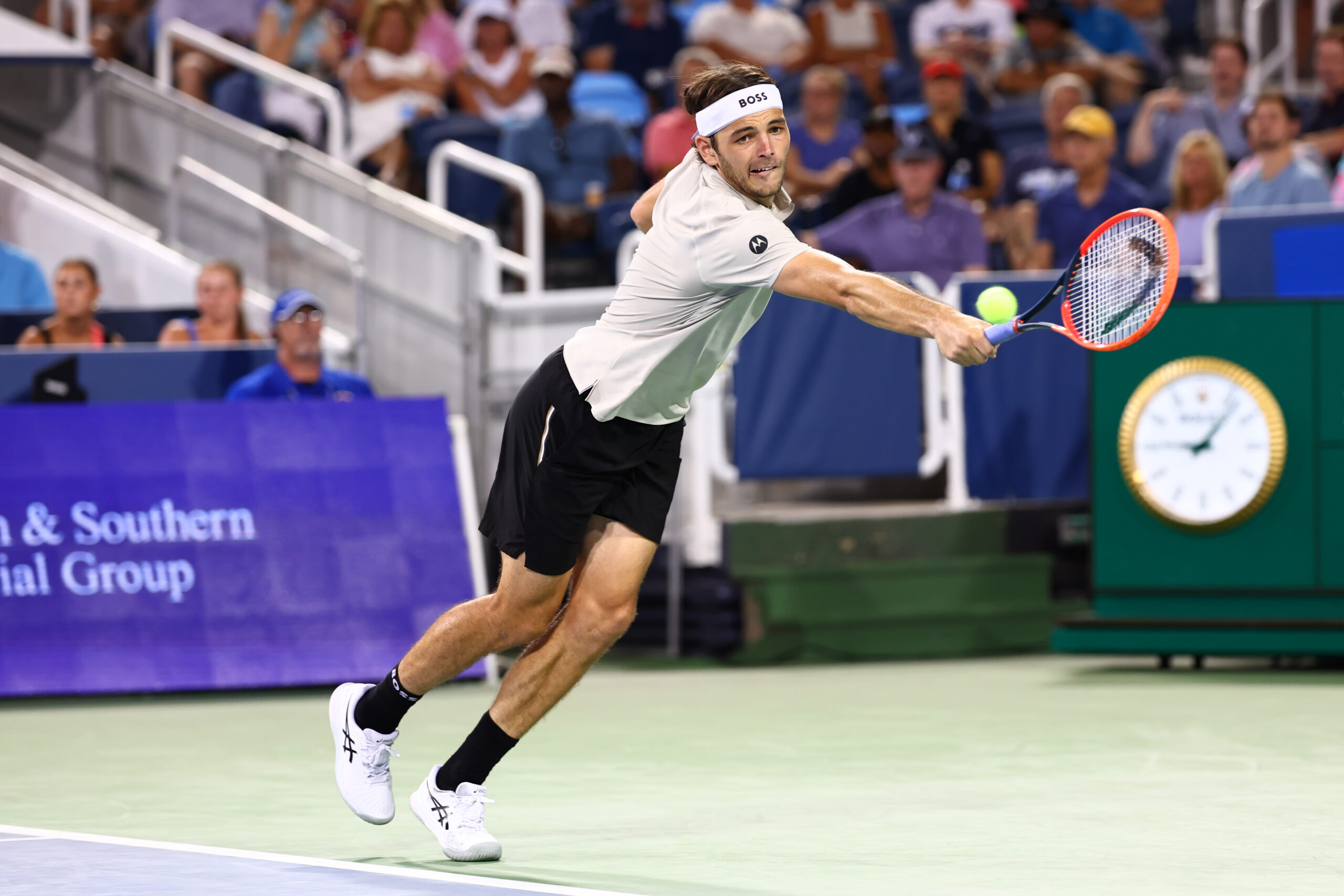 Taylor Fritz hits tennis ball.