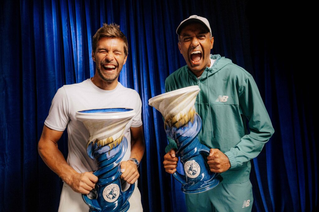 Rajeev Ram and Nikola Mektic holding trophys and smiling