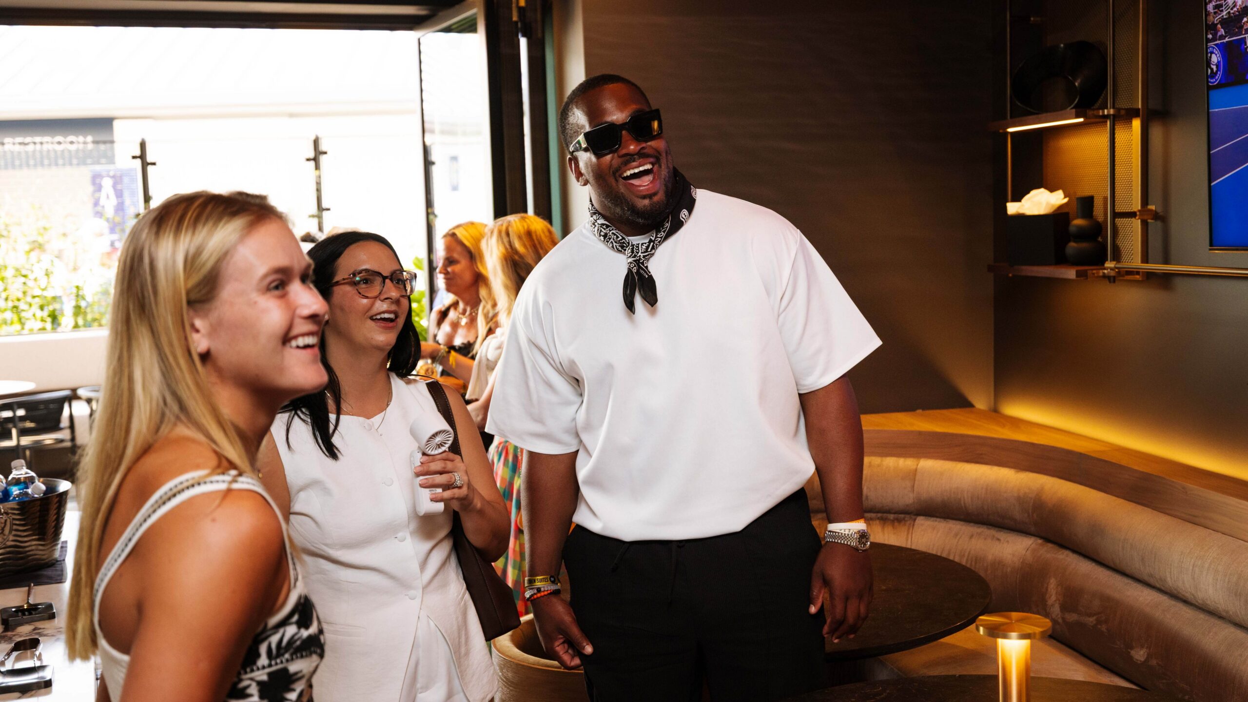 Three people in white smiling at the camera in the garden suite