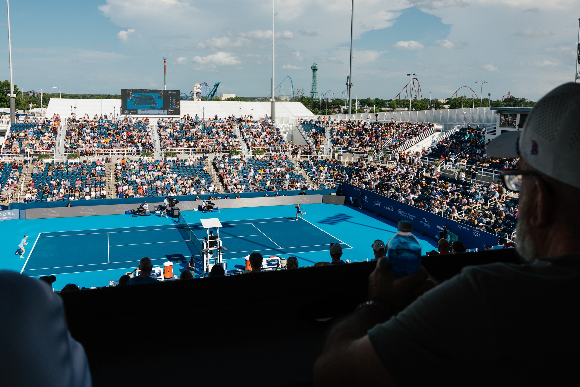 overhead view of a tennis match with a crowd full of spectators