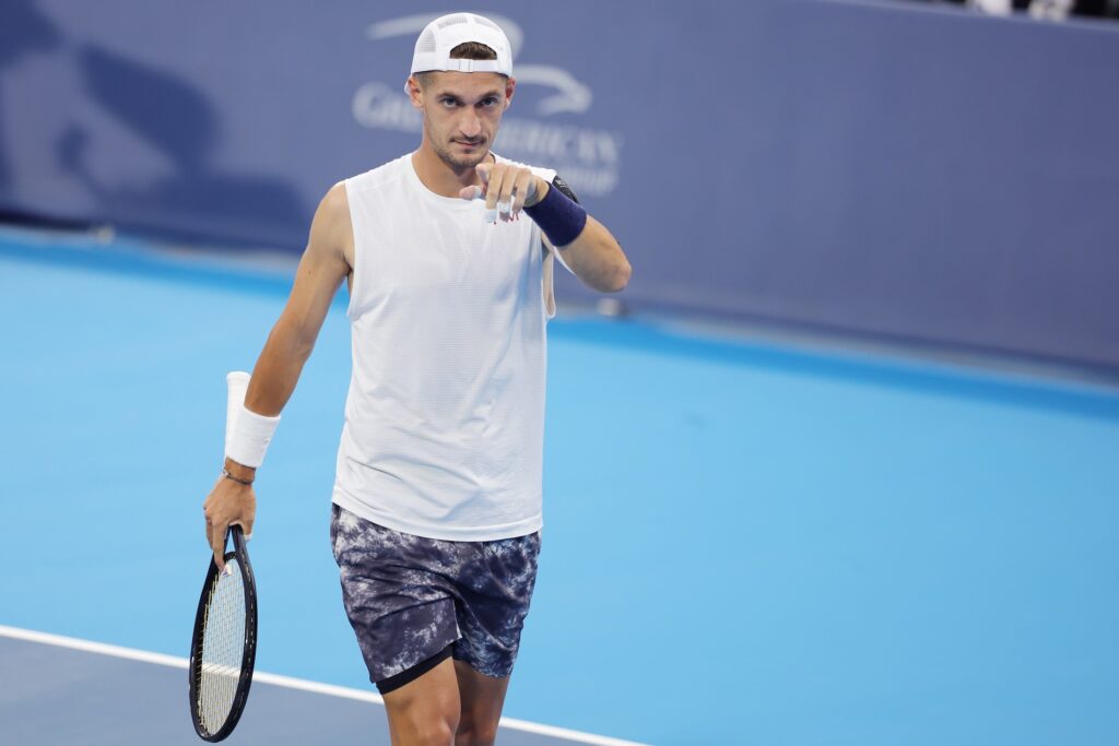 ATP tennis player on court pointing at the camera, ready to start the match