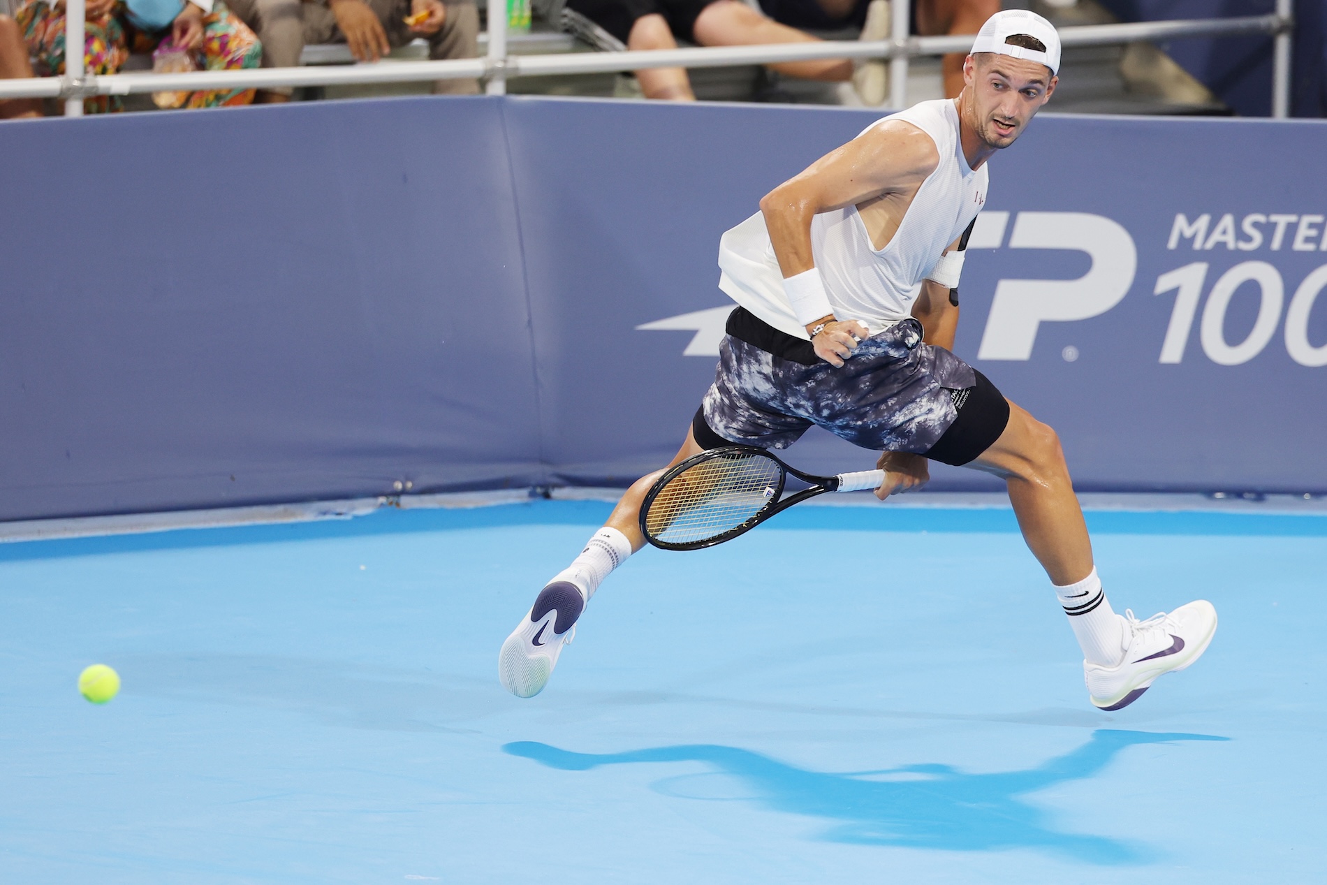 male tennis player mid-match with the racquet between his legs