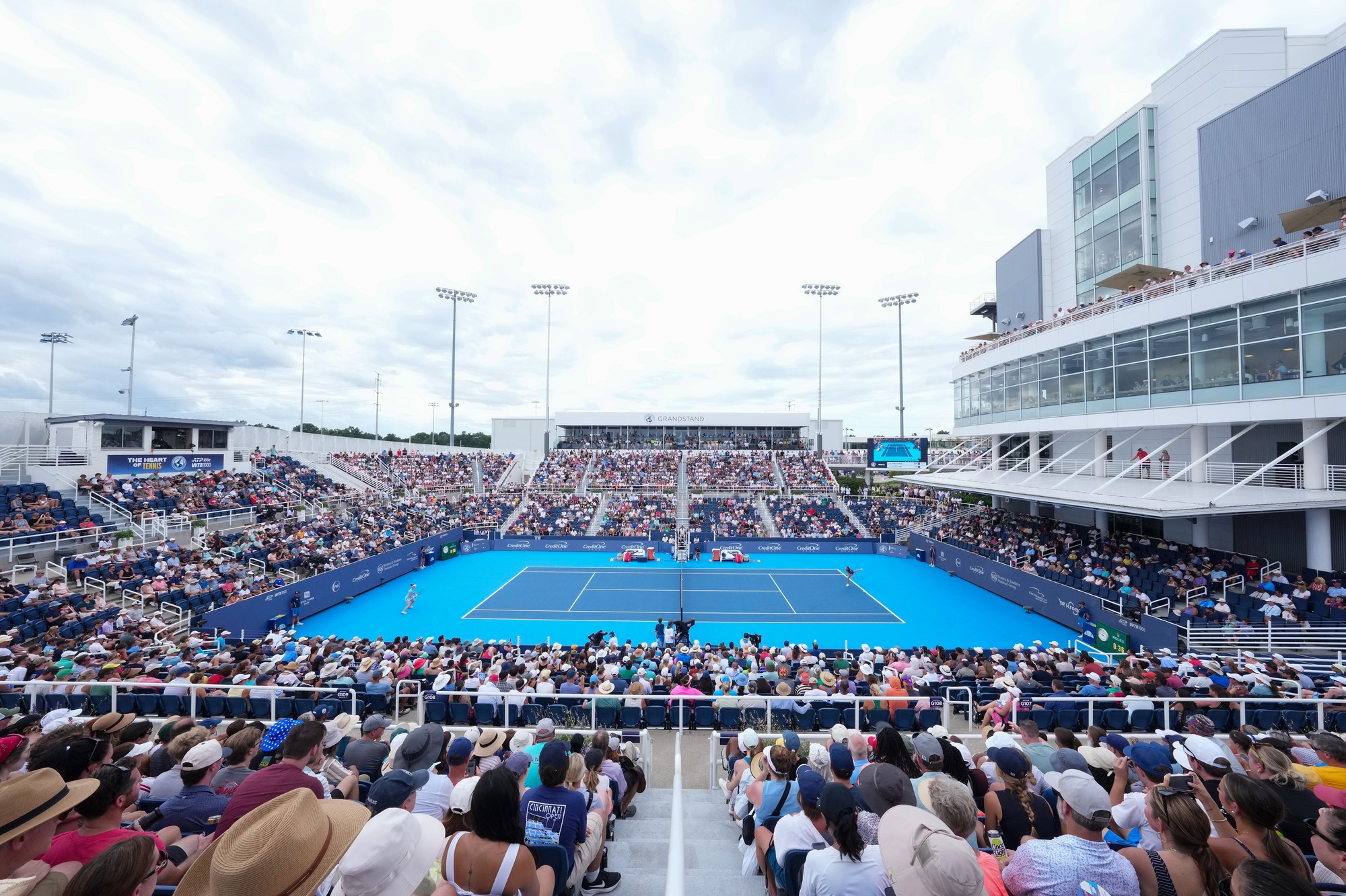 overhead view of a tennis match with a crowd full of spectators