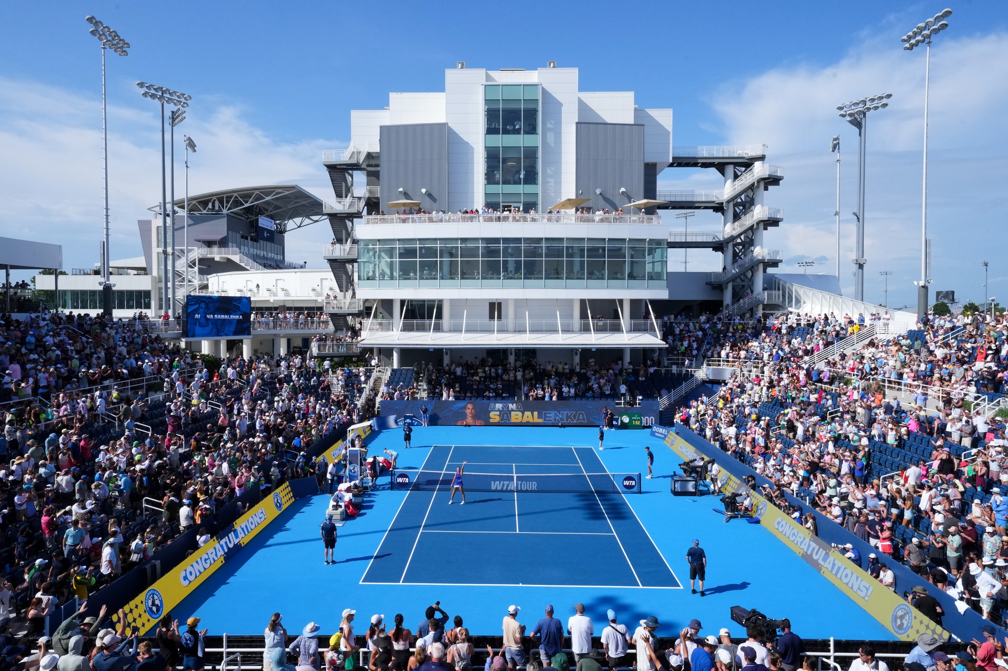 overhead view of a tennis match with a crowd full of spectators
