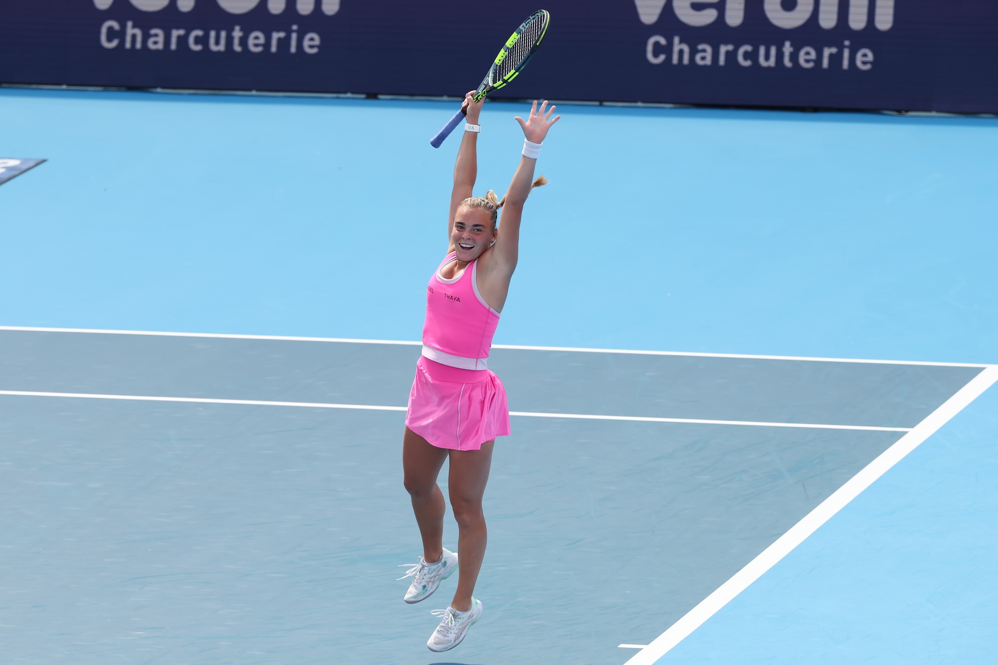 Sara Bejlek raises both arms while wearing pink