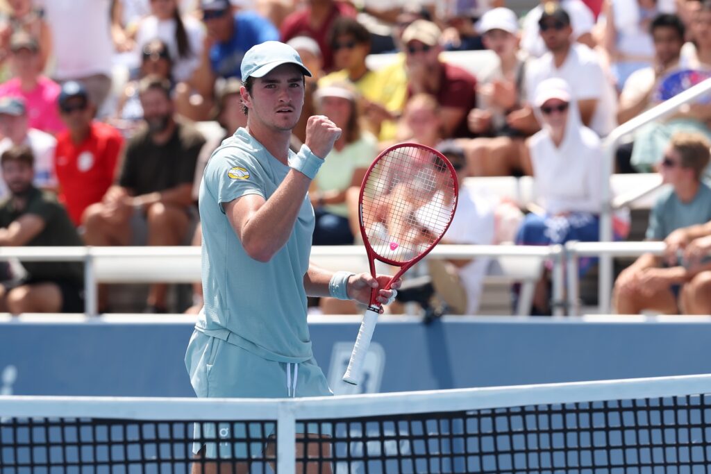 Fonseca pumps his fist while standing next to the net