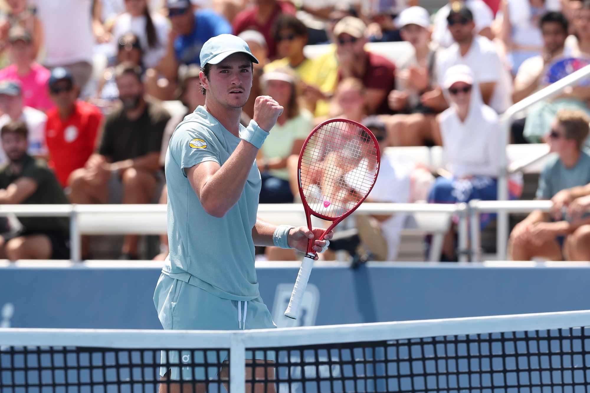 Fonseca pumps his fist while standing next to the net