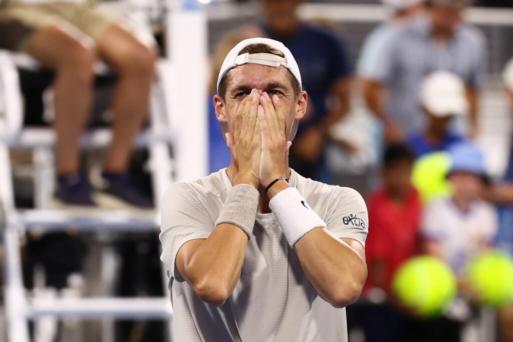 ATP player on court covers his face as he gets emotional at the end of a match